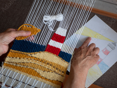 Artisan is checking tapestry against pattern. Tapestry weaving process. Concept of craftsmanship, handmade work