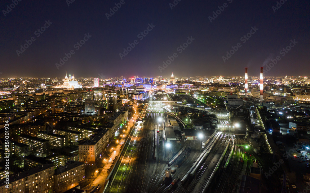 Fototapeta premium high-rise buildings and transport metropolis, traffic and blurry lights of cars on multi-lane highways and Kiyevsky railway station at night in Moscow.