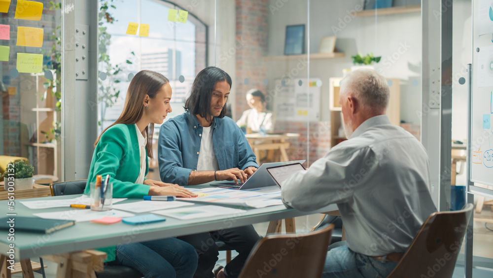 In the Stylish Modern Office Meeting Room: Diverse Group of Business Growth Marketing Professionals Use Laptop and Tablet, Discuss Project Ideas, Brainstorm Company Strategies. Medium Shot.