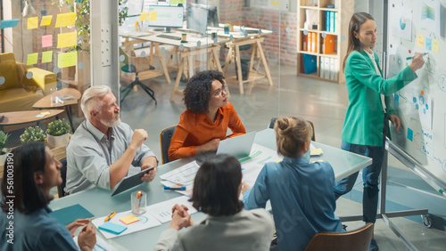 Foto Female CEO Holding a Conference in a Meeting Room, Explaining EDI Concepts to Employees Using a Whiteboard