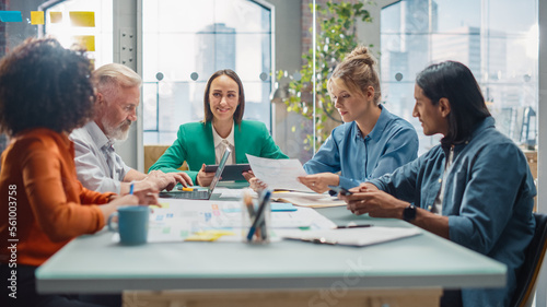 In the Stylish Modern Office Meeting Room: Diverse Group of Business Growth Marketing Professionals Use Laptop and Tablet, Discuss Project Ideas, Brainstorm Company Strategies