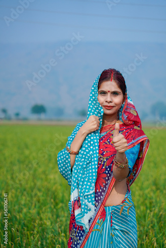 Indian rural woman showing thumps up at agriculture field