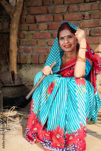 Indian woman making tea on traditional kitchen. rural india