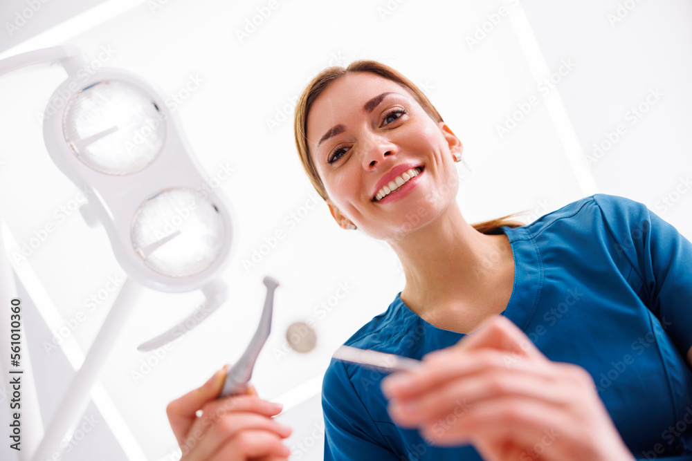 Dentist holding dental drill fixing patinet tooth Dentist holding dental drill fixing patinet tooth