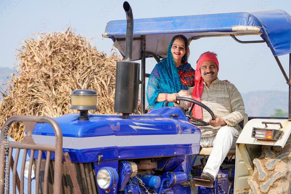 Indian farmer sitting on tractor with wife at agriculture field. Stock ...