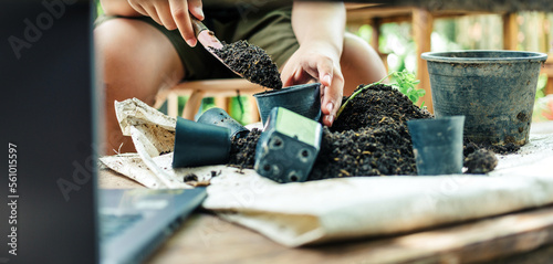 Boy hands shoveling soil into pots to prepare plants for planting leisure activities concept