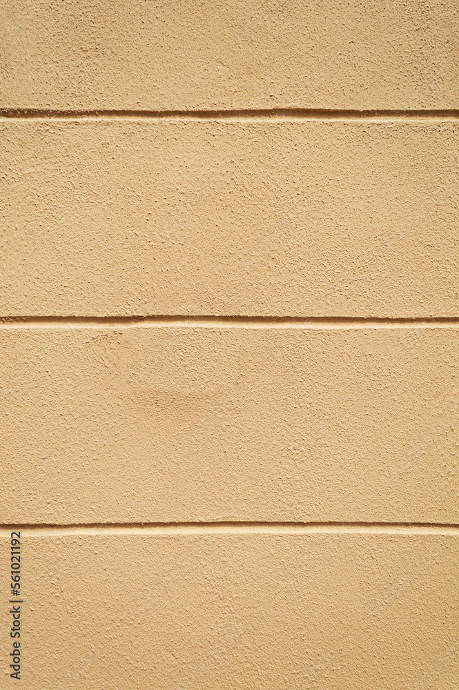 Fototapeta premium Beige masonry wall with grooves. Vertical. Advertising space.