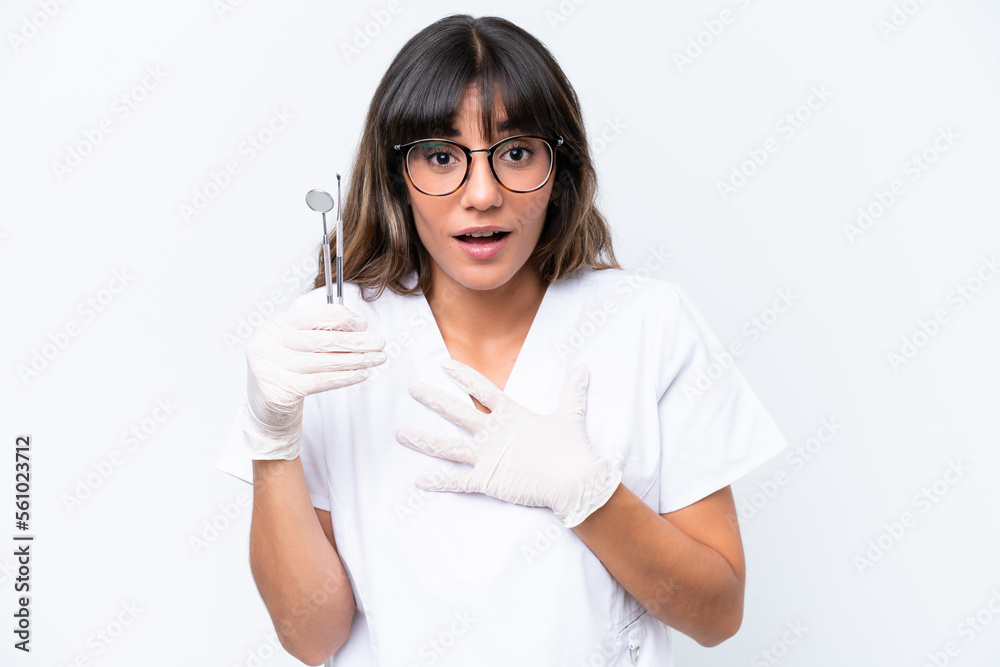 Dentist caucasian woman holding tools isolated on white background surprised and shocked while looking right Dentist caucasian woman holding tools isolated on white background surprised and shocked while looking right