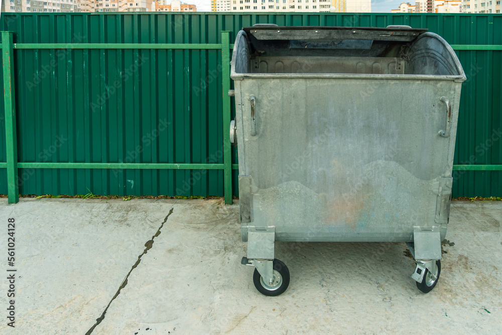 Modern metal containers for separate garbage collection. Garbage cans in the city on the background of a house. Environmental disaster, problems of waste removal, collection and disposal in a big city Modern metal containers for separate garbage collection. Garbage cans in the city on the background of a house. Environmental disaster, problems of waste removal, collection and disposal in a big city