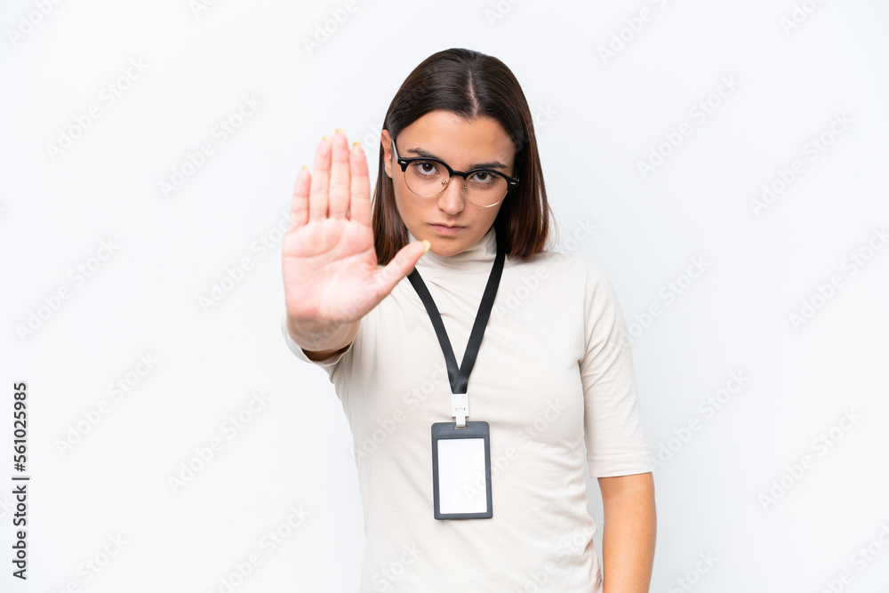 Young caucasian woman with ID card isolated on white background making stop gesture Young caucasian woman with ID card isolated on white background making stop gesture
