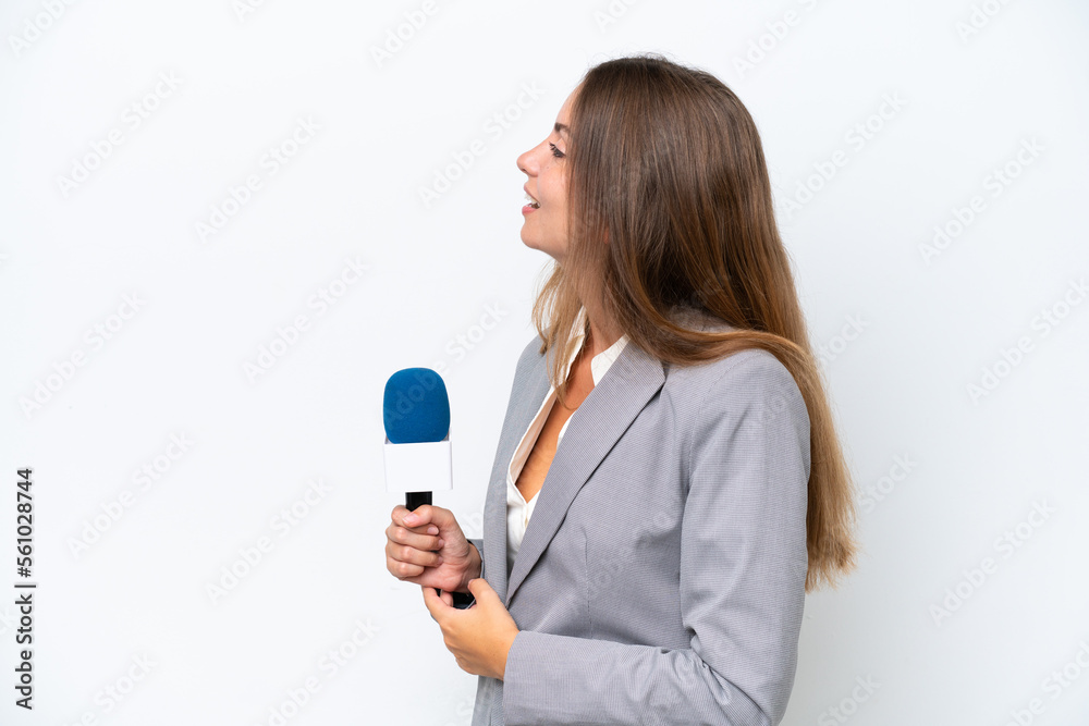 Young TV presenter caucasian woman isolated on white background laughing in lateral position Young TV presenter caucasian woman isolated on white background laughing in lateral position