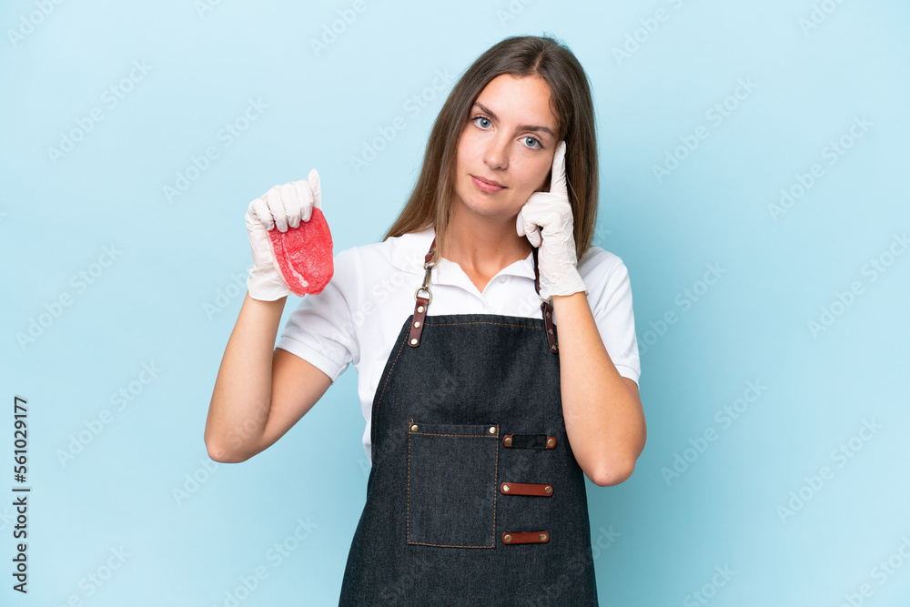 Butcher caucasian woman wearing an apron and serving fresh cut meat isolated on blue background thinking an idea Butcher caucasian woman wearing an apron and serving fresh cut meat isolated on blue background thinking an idea