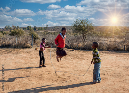 Obraz na plátne three african friends skipping rope in the village