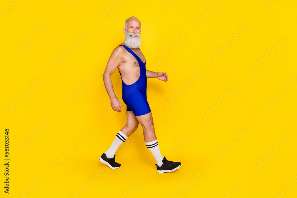 Full length profile photo of old funny excited positive guy hurry run wear blue costume good mood going gym training isolated on bright yellow color background