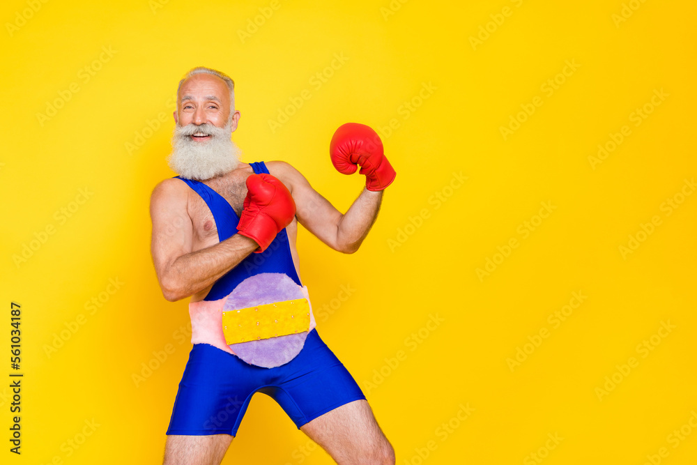 Portrait of positive aged person arms boxing gloves punch empty space isolated on yellow color background Portrait of positive aged person arms boxing gloves punch empty space isolated on yellow color background