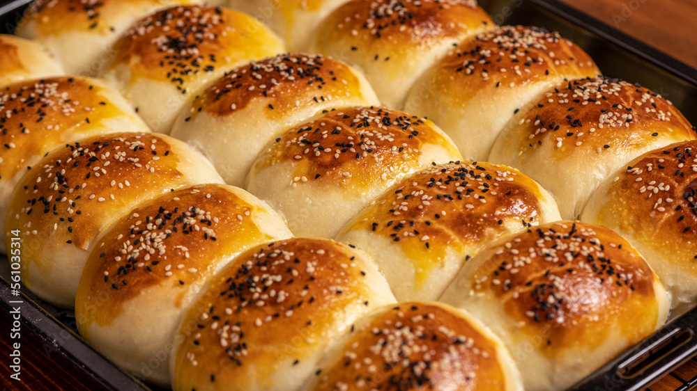 Freshly baked buns on the baking tray, close-up.