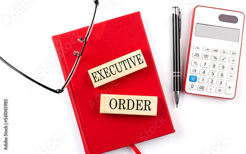 EXECUTIVE ORDER text on wooden block on red notebook