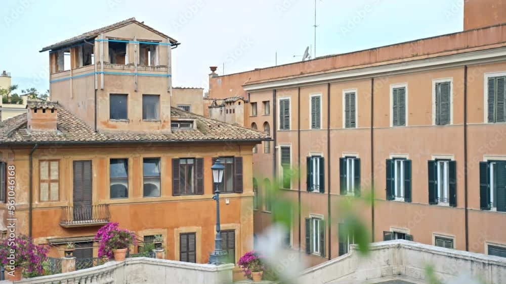 Architecture of an old Roman city with its uniques features, residential buildings with small balconies, old window shutters and terraces decorated with greenery, vintage street lamps illuminating at Architecture of an old Roman city with its uniques features, residential buildings with small balconies, old window shutters and terraces decorated with greenery, vintage street lamps illuminating at