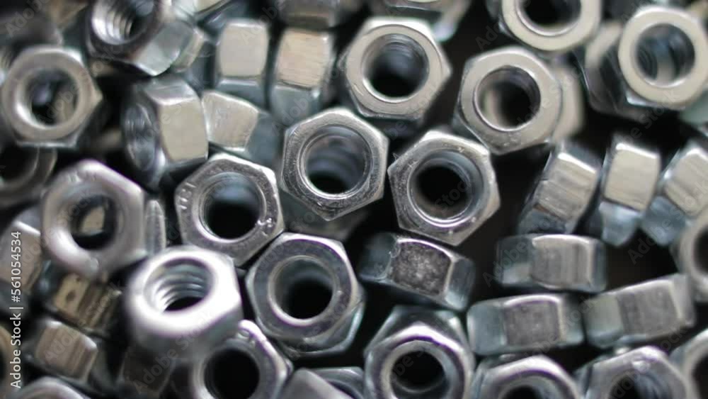 Many stainless hex nuts rotating close-up. Metal industry concept. Many stainless hex nuts rotating close-up. Metal industry concept.