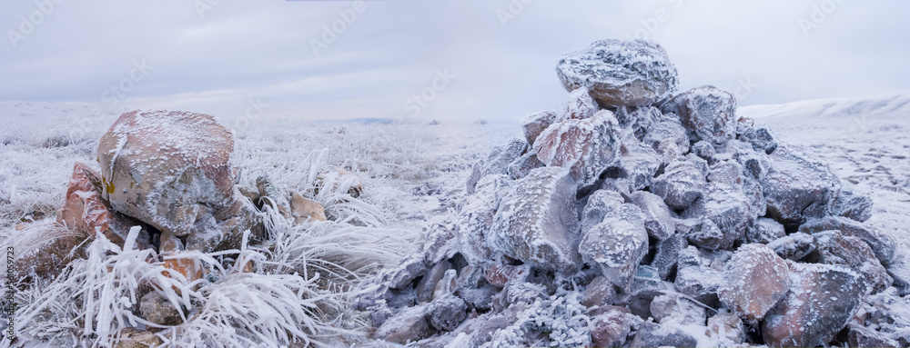 closeup heap of stones among snowbound plain, winter natural landscape