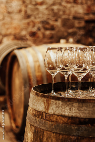 Wine glasses and barrels in the wine cellar