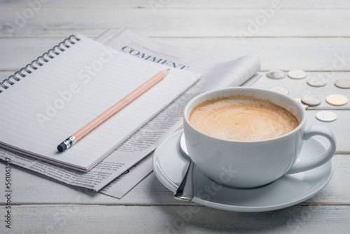 Black cup of coffee, notebook, newspaper and laptop on the table, morning news. get ready for work in the morning