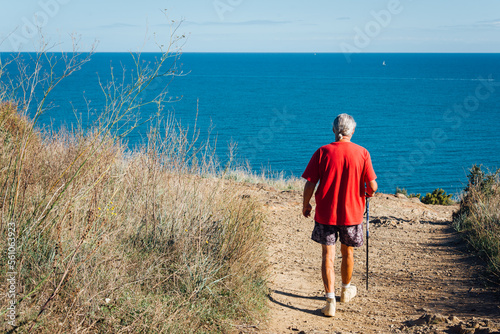Obraz na płótnie Un homme retraité marchant au bord de la mer