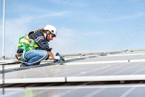 Male engineer installing or checking the working condition of solar panels on the roof or at the height of the factory for saving electricity was broken to use renewable energy from the sun