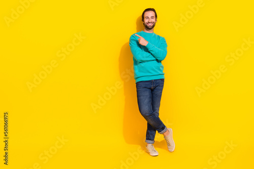 Full length photo of cheerful positive guy dressed teal outfit pointing finger empty space isolated yellow color background
