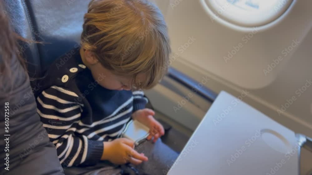 Passenger child putting seat belt on seated inside airplane waiting for plane to take off. Departure concept Passenger child putting seat belt on seated inside airplane waiting for plane to take off. Departure concept