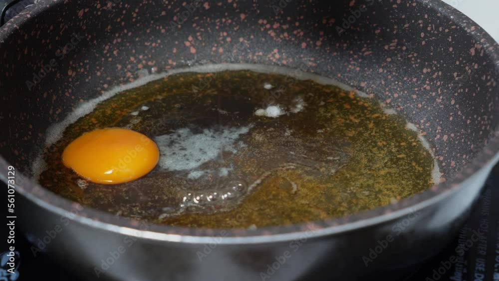 Woman cooking homemade Fried eggs in a pan for breakfast. Broken egg falls into the frying pan. Cooking Scrambled Eggs Frying Eggs on the Stove, The Concept of Protein Healthy Food and Diet. Woman cooking homemade Fried eggs in a pan for breakfast. Broken egg falls into the frying pan. Cooking Scrambled Eggs Frying Eggs on the Stove, The Concept of Protein Healthy Food and Diet.