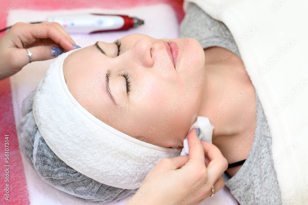 Procedure at a cosmetologist, cleansing the face of cosmetics and preparing the face for massage.