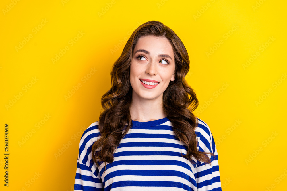 Photo of dreamy adorable young lady wear striped shirt smiling looking empty space isolated yellow color background Photo of dreamy adorable young lady wear striped shirt smiling looking empty space isolated yellow color background