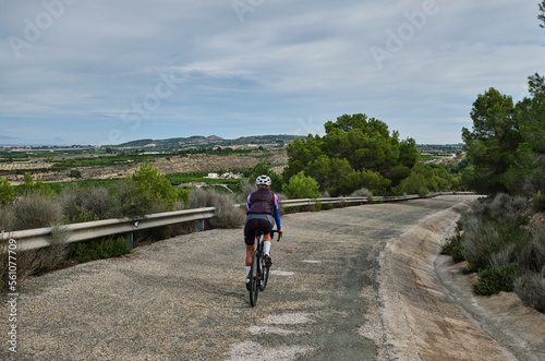 woman cyclist riding a gravel bike with a view of the mountains, Murcia region of Spain