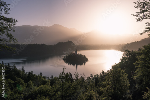 Lake Bled mit Insel und Kirche in goldenem Morgenlicht über dem See.