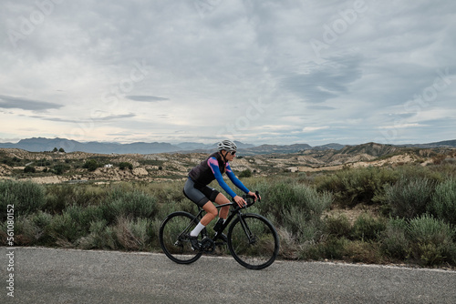 woman cyclist riding a gravel bike with a view of the mountains, Murcia region of Spain