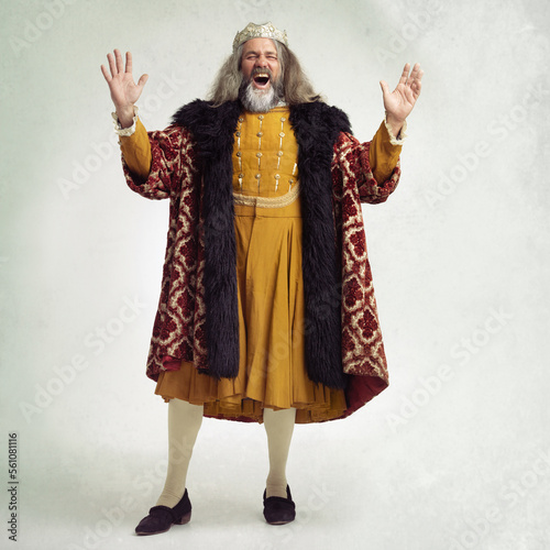 Ancient king man, screaming and studio with laugh, funny and renaissance fashion by backdrop. Medieval royal leader, clothes and laughing with crown, happiness and robe for power, success and luxury