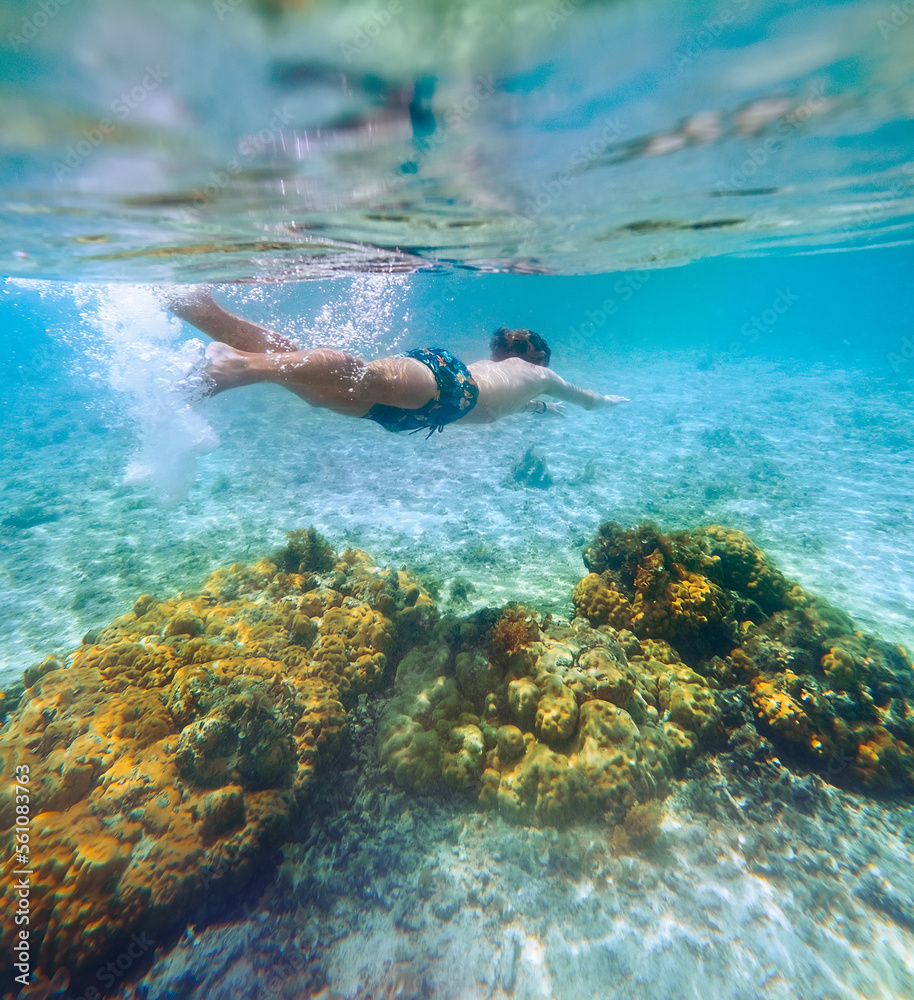 Diving teenage boy snorkeling over the coral reefs underwater photo in the clean turquoise lagoon on Le Morne beach. Mauritius island. Exotic traveling and underwater eco concept.