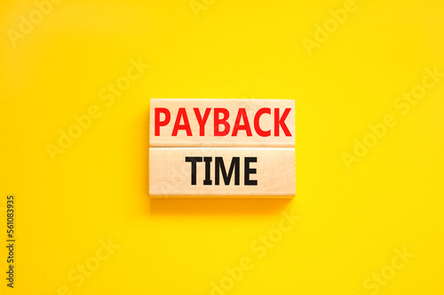 Payback time symbol. Concept words Payback time on wooden blocks. Beautiful yellow table yellow background. Business and payback time concept. Copy space. photo
