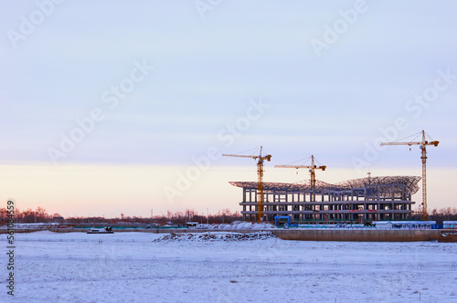 Winter view of the construction of the terminal of the international cable car between Russia and China on the banks of the Amur River. State border on a frosty morning. Barbed wire fences on ice.
