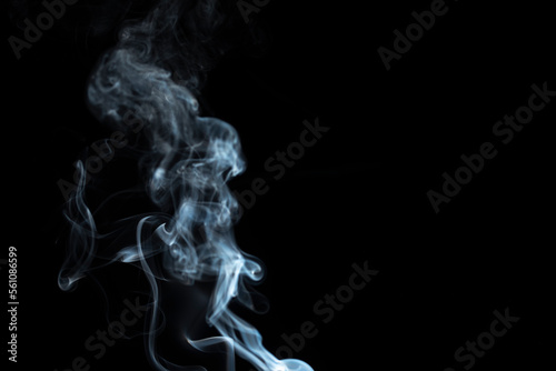 incense stick with white smoke against black background