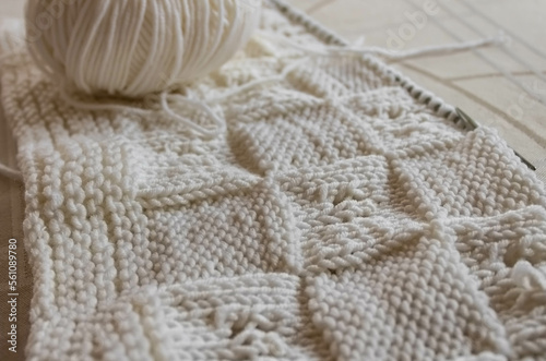 White knitting wool texture closeup, a ball of white wool and knitting needle background