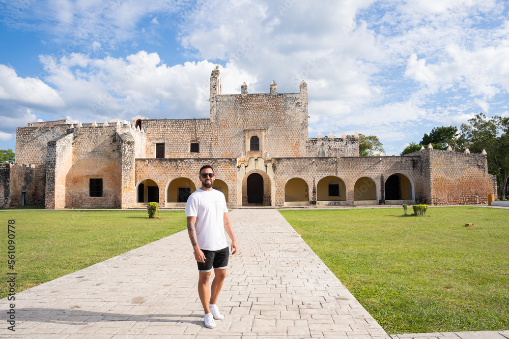 Young male tourist outside the San Bernardino Convent with the manicured green lawn in Valladolid, Mexico.