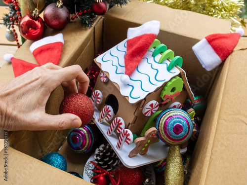 Hand taking down Christmas decorations into carton box photo