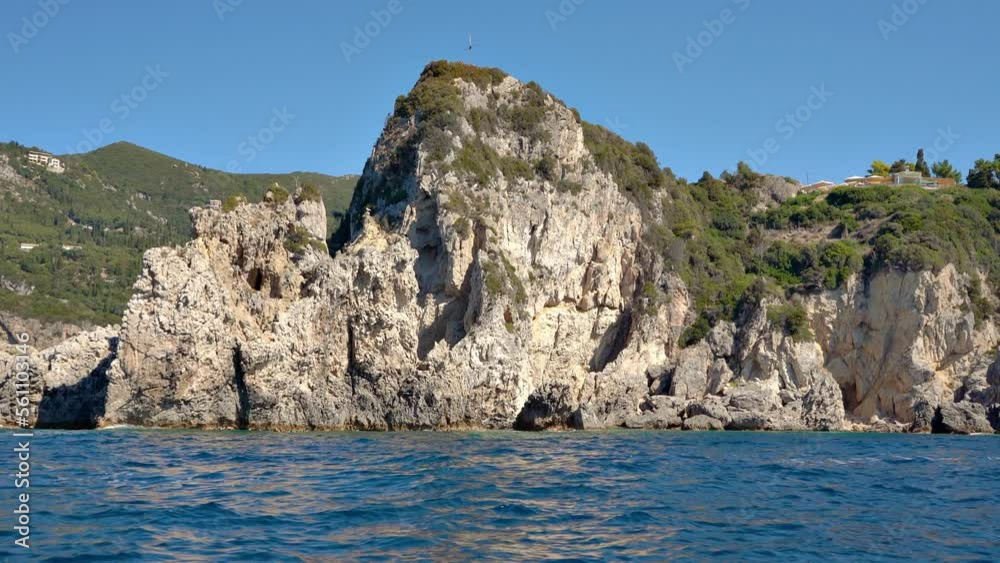 Sharp tall rocky cliffs visible above water - typical seascape near Paleokastritsa, Corfu Greece, view from a boat Sharp tall rocky cliffs visible above water - typical seascape near Paleokastritsa, Corfu Greece, view from a boat