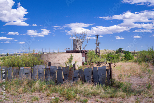 Marfa, Texas decrepit yard with sheet metal fence, concrete cistern, sheet metal water rainwater collector, and dilapidated windmill photo
