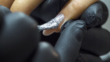 Brush with shiny silver polish paint to apply nail polish on women's nails