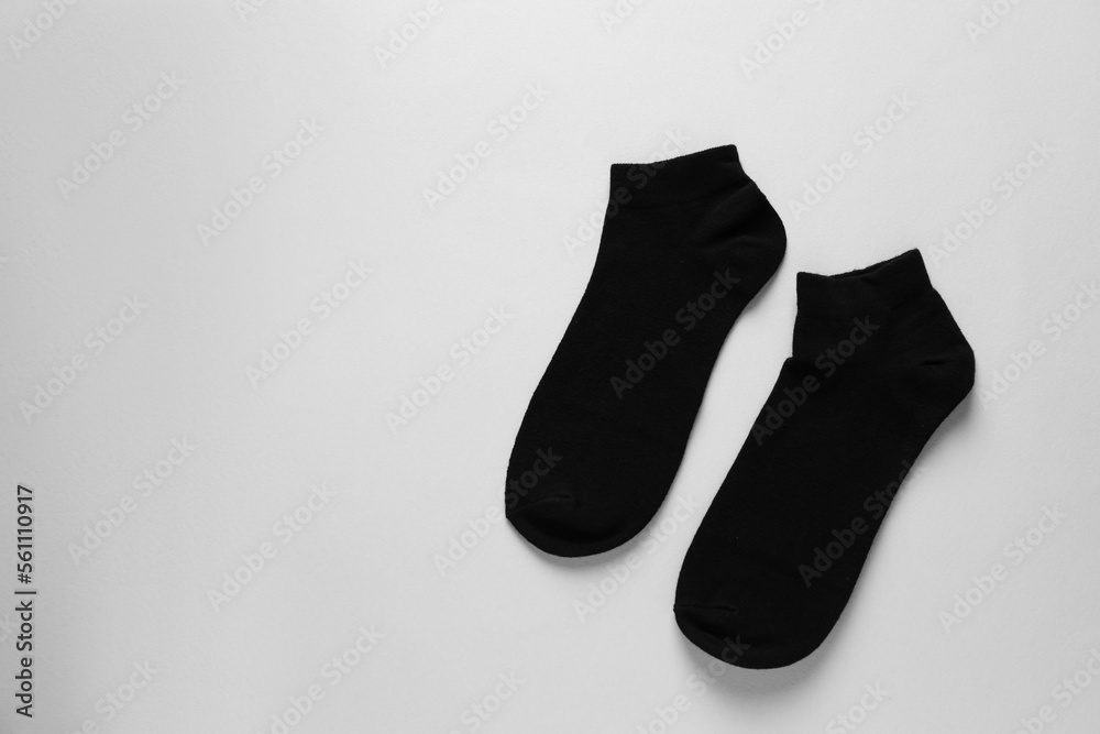 Pair of black socks on light grey background, flat lay. Space for text Pair of black socks on light grey background, flat lay. Space for text