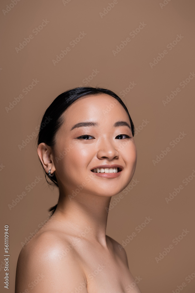 happy asian woman with perfect skin and natural makeup looking at camera isolated on brown. happy asian woman with perfect skin and natural makeup looking at camera isolated on brown.