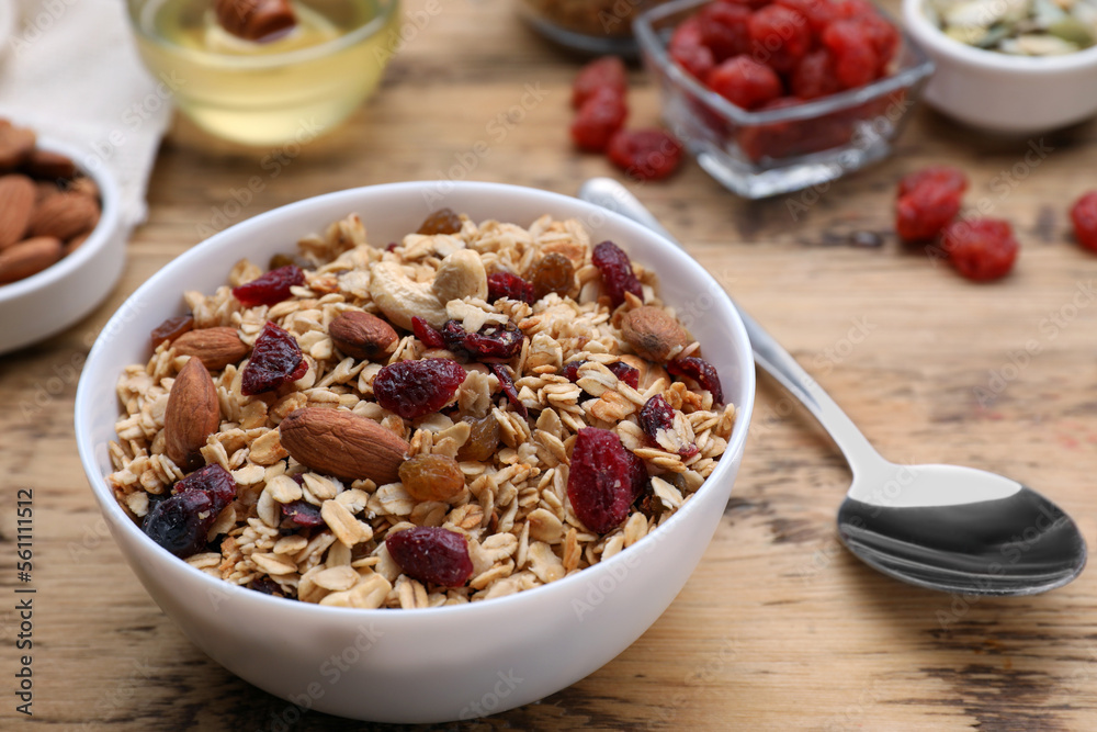Tasty granola served with nuts and dry fruits on wooden table, closeup Tasty granola served with nuts and dry fruits on wooden table, closeup